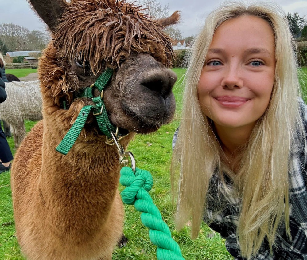 Woman smiling with an alpaca